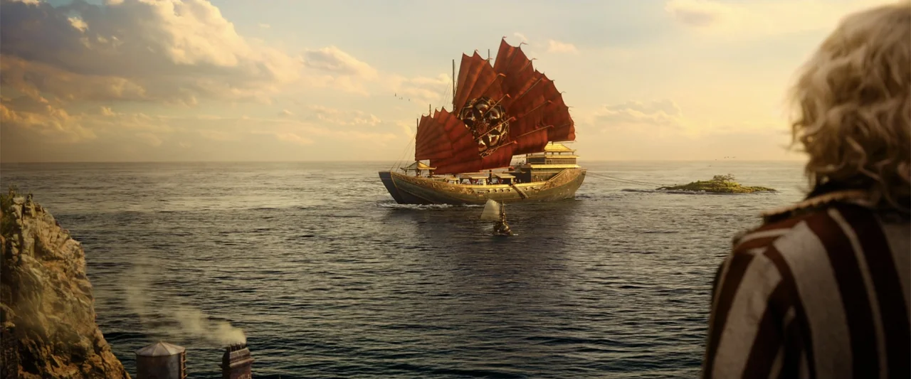 Jim Button and Luke the Engine Driver (2018) movie still: wide — A vast ocean scene is viewed from a high rocky cliff during golden hour. A large…