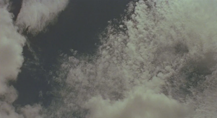 Yi-Yi (A One and A Two) (2000) movie still: establishing — Clouds drift across a wide expanse of daylight sky. White cumulus formations are…