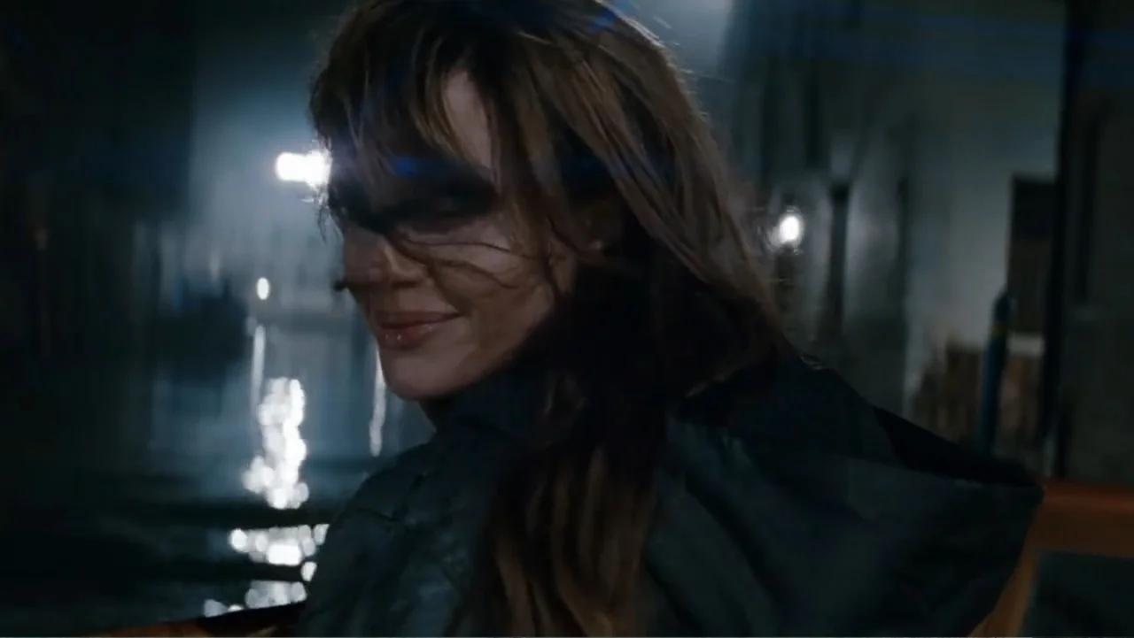 The Tourist (2010) movie still: closeup — A woman sits on a boat at night on a dark urban canal. The subject turns her head to look toward the…