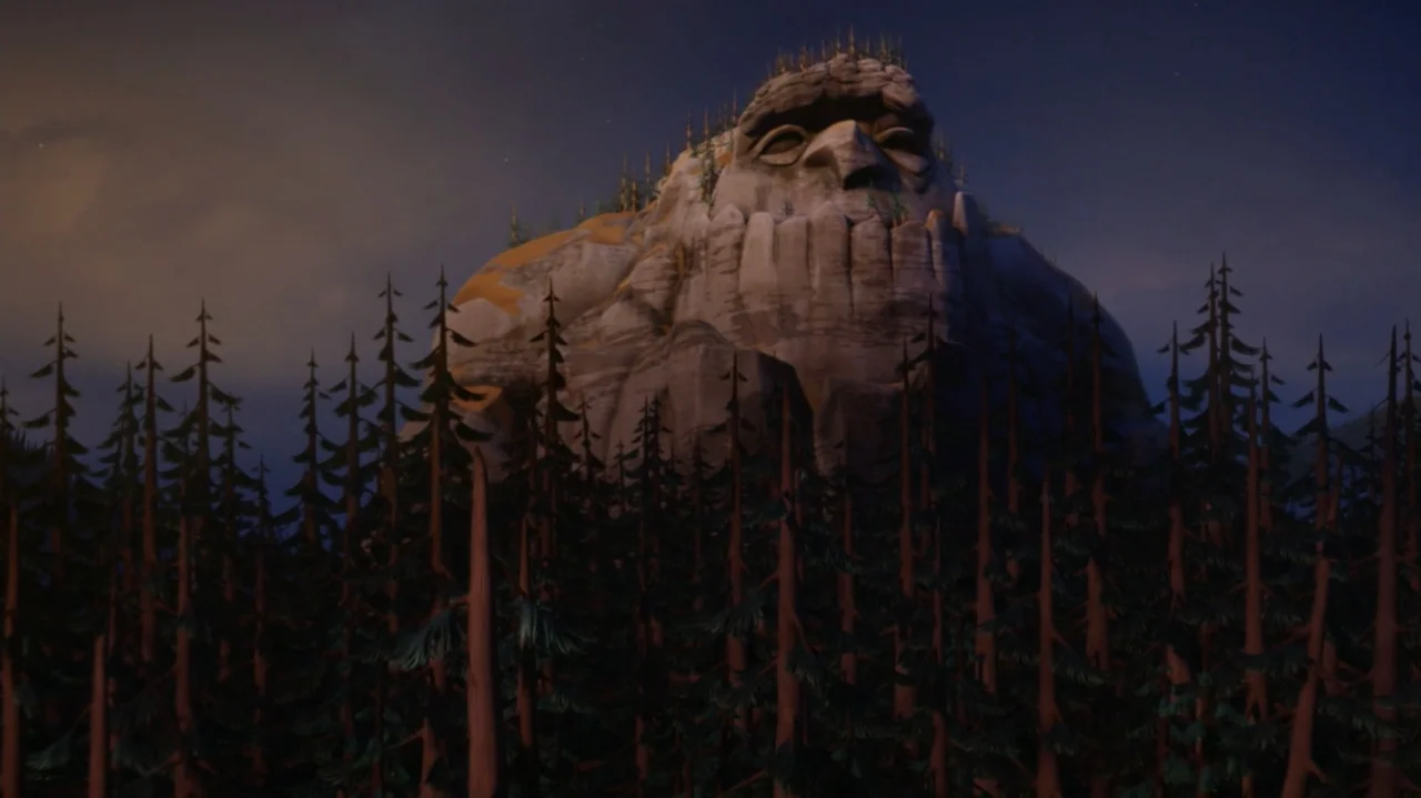 Troll: The Tale of a Tail (2018) movie still: wide — A dark mountainous landscape at night features a towering stone ridge shaped like a face. Tall…