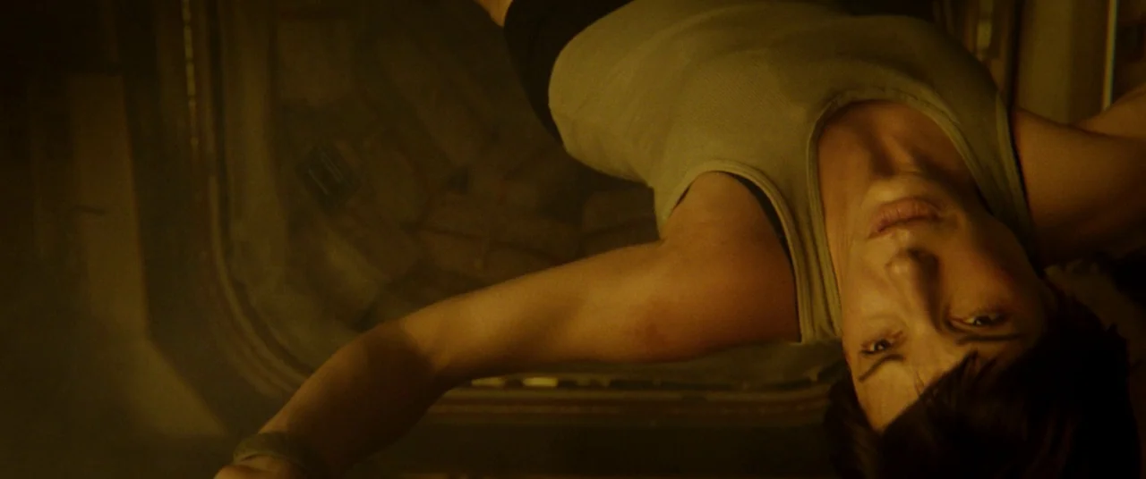 Gravity (2013) movie still: closeup — A confined metallic environment with rounded corners suggests the interior of a spacecraft module. A woman in…