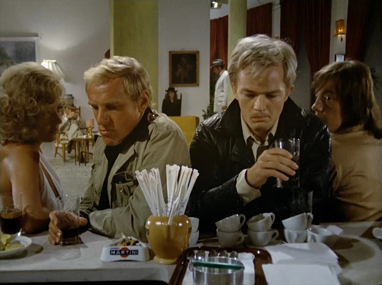 Beware Of A Holy Whore (1971) movie still: medium — A dimly lit bar counter features several white ceramic cups and a martini ashtray. Two men sit…