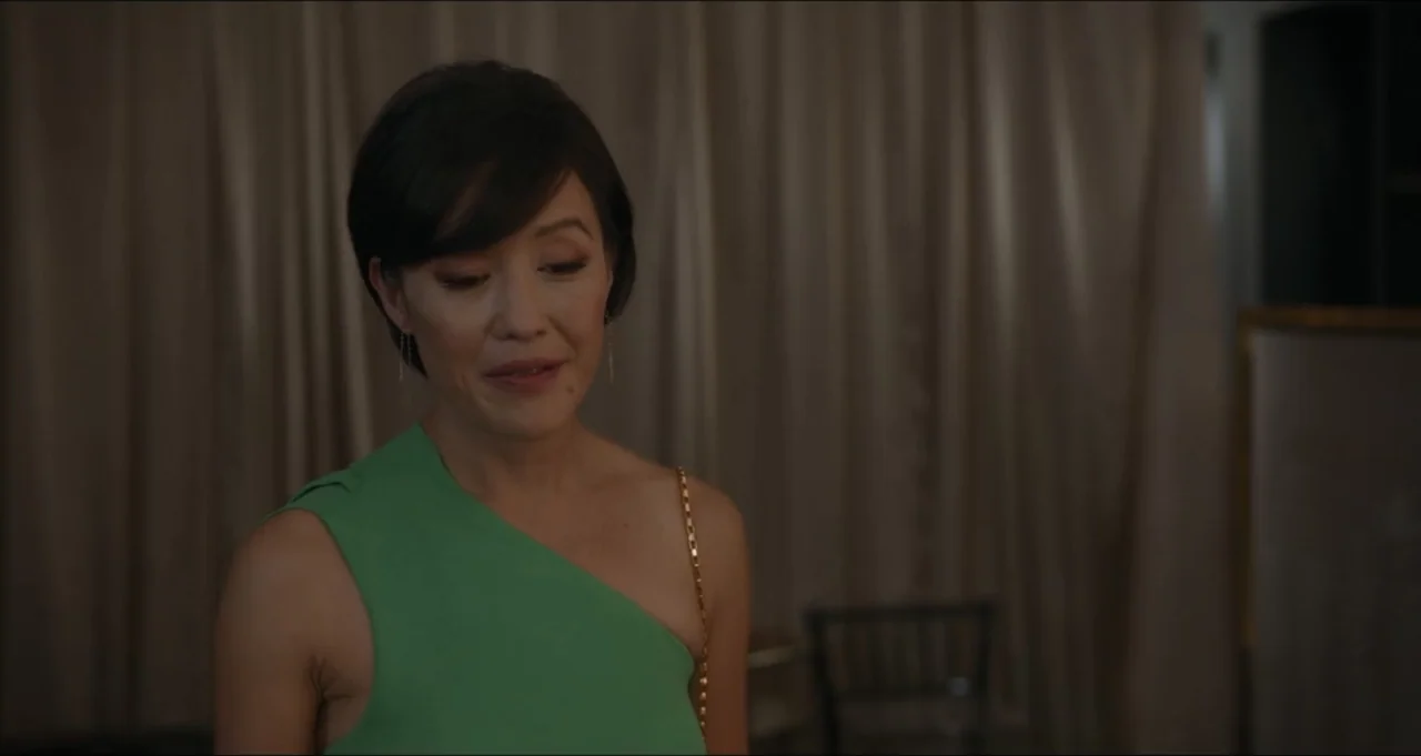 Five Blind Dates (2024) movie still: medium — An interior space features a person standing against a background of draped fabric curtains. A woman…