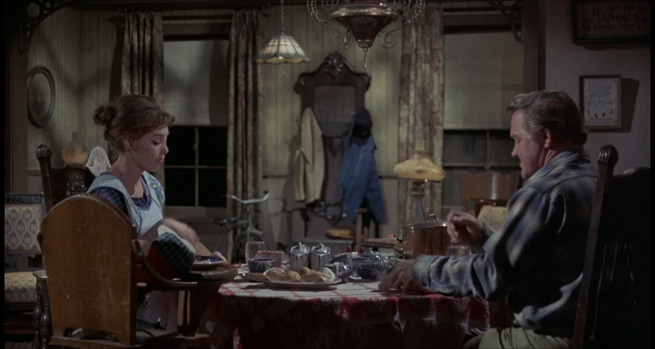 The Dunwich Horror (1970) movie still: medium — An interior dining area featuring wood-paneled walls and a table set for dinner at night. A man and…