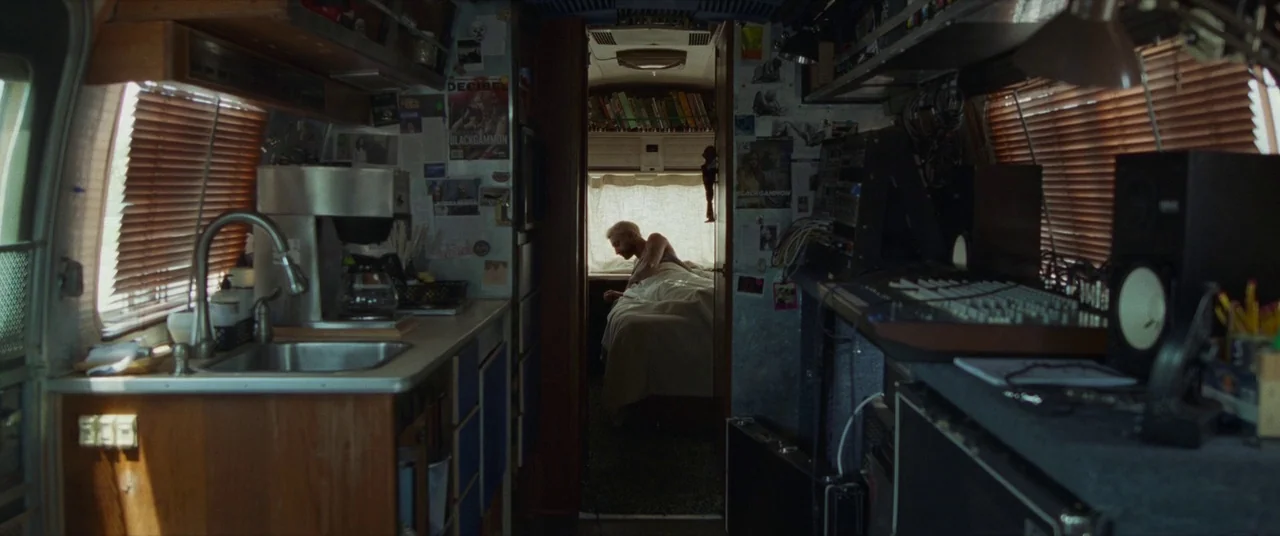 Sound of Metal (2019) movie still: wide — A cluttered campervan interior features a compact kitchenette in the foreground with a sink. In the…