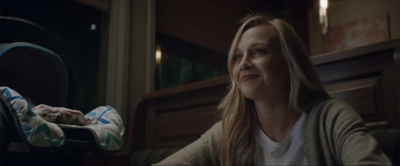 Gender Under Attack (2018) movie still: medium — A dimly lit restaurant booth at night featuring dark wooden paneling in the background. A woman in…