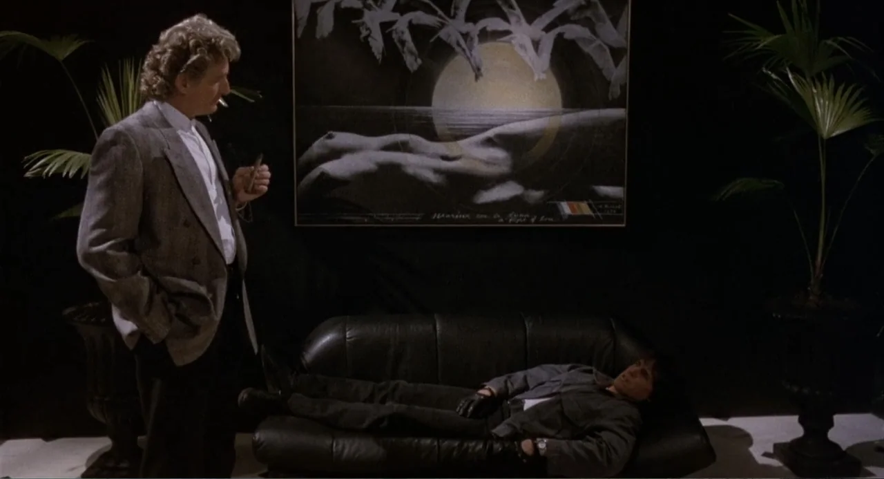 American Ninja 3: Blood Hunt (1989) movie still: medium — A dark interior room features black walls, two potted palms, and a wall painting. An older…