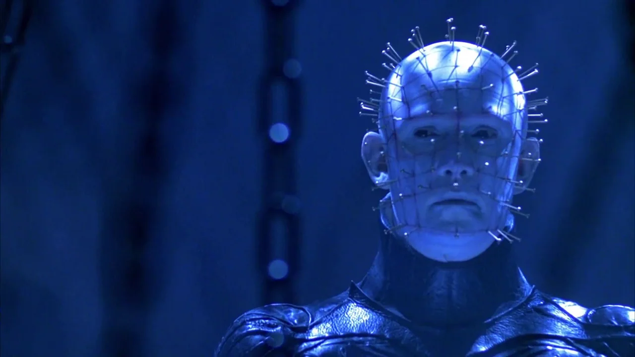 Hellraiser: Bloodline (1996) movie still: closeup — A figure with a pale head covered in metal needles stands against a blue background. The subject…