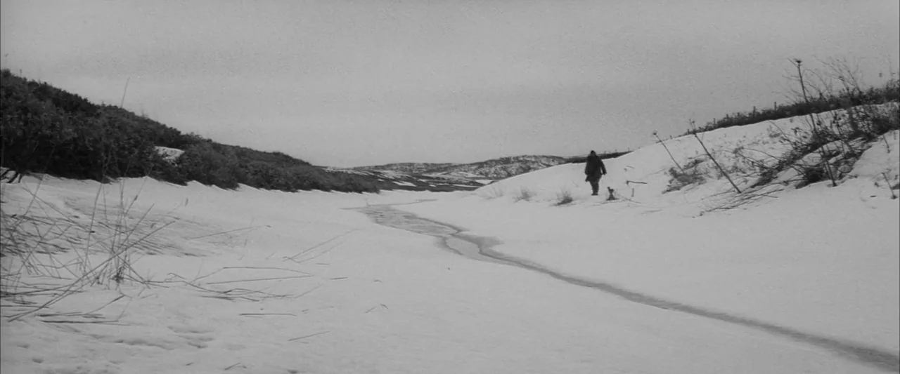 The Human Condition III: A Soldier’s Prayer (1961) movie still: wide — A vast, desolate, snow-covered landscape with a narrow frozen stream cutting…