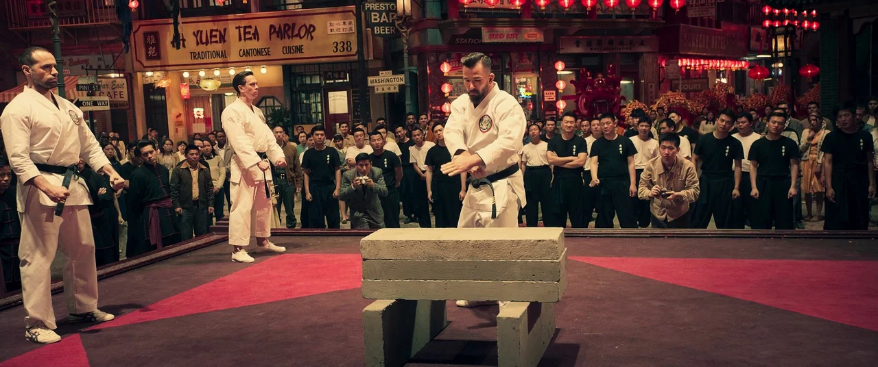 Ip Man 4: The Finale (2019) movie still: wide — A busy urban intersection in a historic district is decorated with hanging red lanterns. A martial…