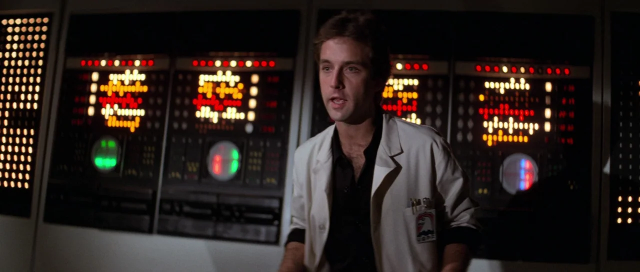 Escape From New York (1981) movie still: medium — A dark, windowless interior space features massive, glowing, multi-colored computer control…