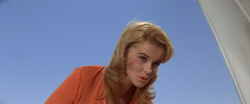 Viva Las Vegas (1964) movie still: closeup — A woman stands outdoors with clear blue sky visible in the background. She looks down towards the…