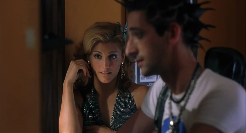 Summer of Sam (1999) movie still: medium — A dimly lit room features a woman looking toward a man in the foreground. The man is partially out of…