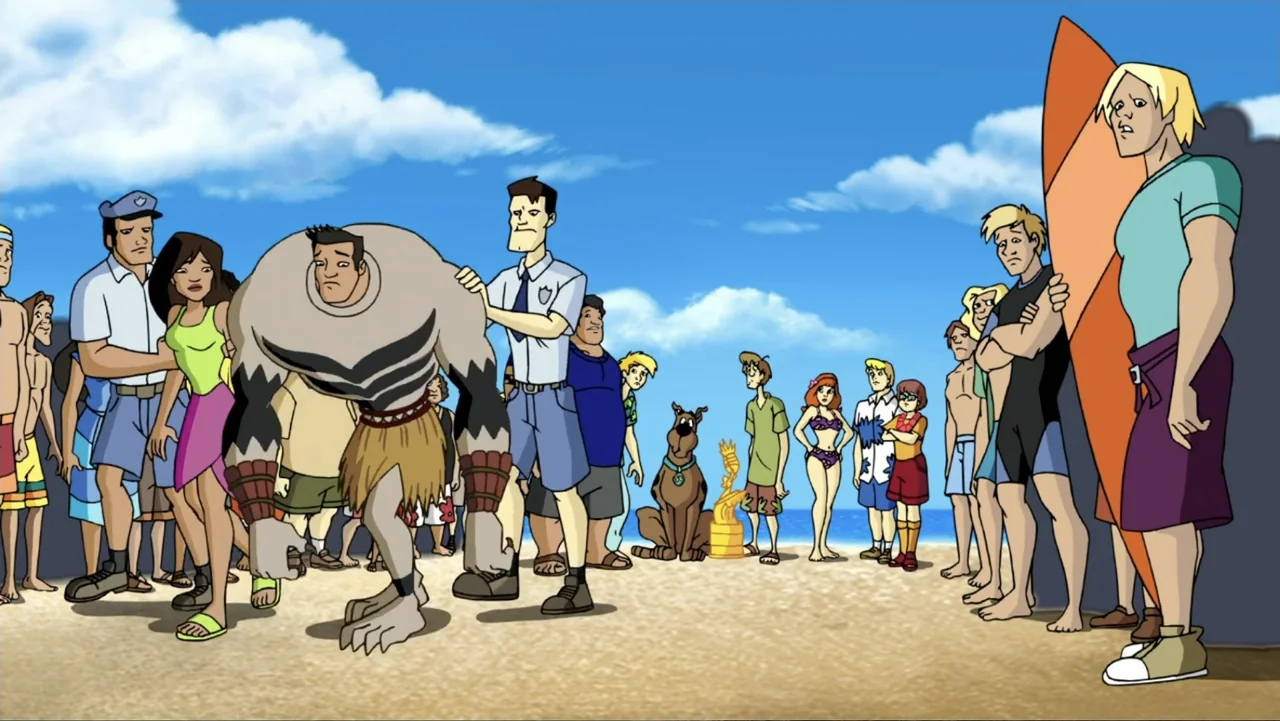 Aloha Scooby-Doo! (2005) movie still: fullbody — A sunny beach filled with a crowd of people watching a large gray monster. The group includes…