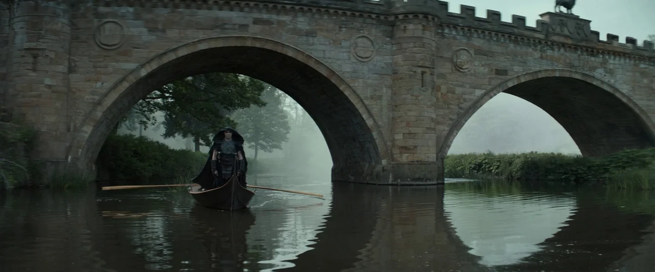 Dungeons & Dragons: Honor Among Thieves (2023) movie still: wide — A stone arched bridge crosses a misty, slow-moving river in a wooded area. A lone…