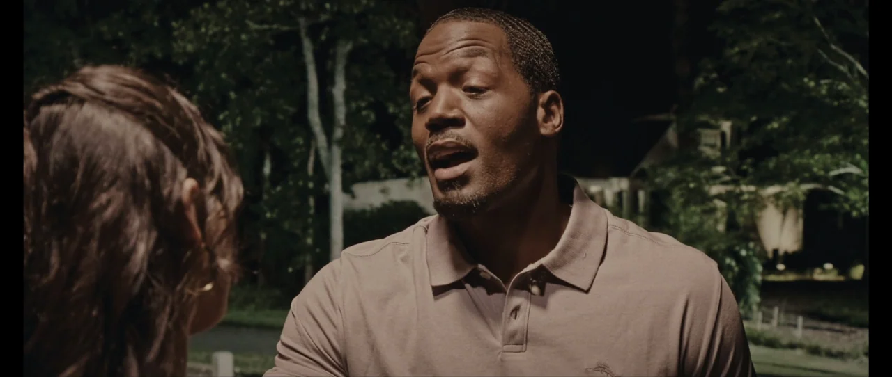 Ordinary Things (2001) movie still: medium — A suburban street at night serves as the setting for a conversation. A man in a polo shirt looks toward…