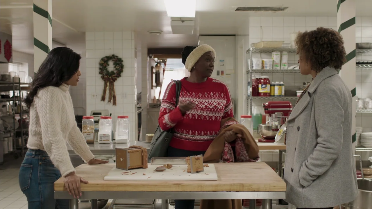 A Gingerbread Christmas (2022) movie still: medium — A professional bakery kitchen features stainless steel prep tables, shelving units, and white…