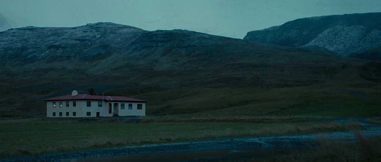 Pawn Sacrifice (2014) movie still: establishing — A low-slung building with a red roof sits alone in a vast valley. Large mountains rise in the…