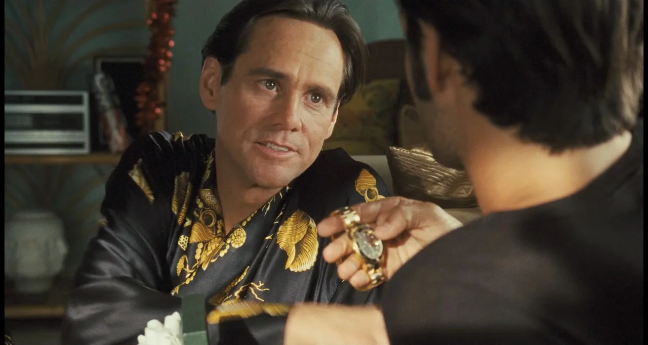 I Love You Phillip Morris (2010) movie still: medium — A well-lit living room setting with a person wearing a gold-patterned robe sitting down. A…