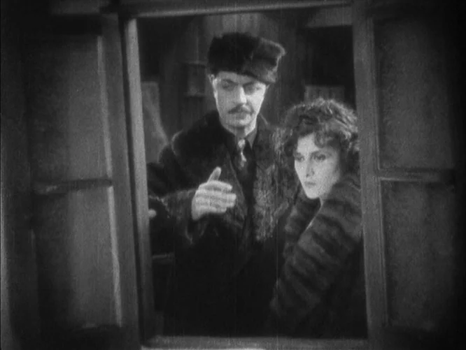 The Last Command (1928) movie still: medium — A man and woman are visible through an open window frame. The man gestures while the woman looks…