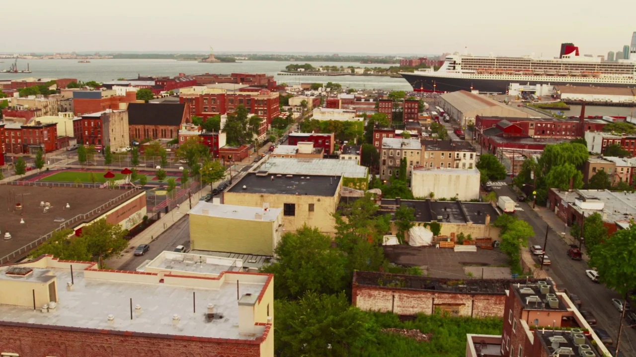 Red Hook Summer (2012) movie still: establishing — A high-angle view looks over a densely built urban neighborhood with low-rise buildings. A…