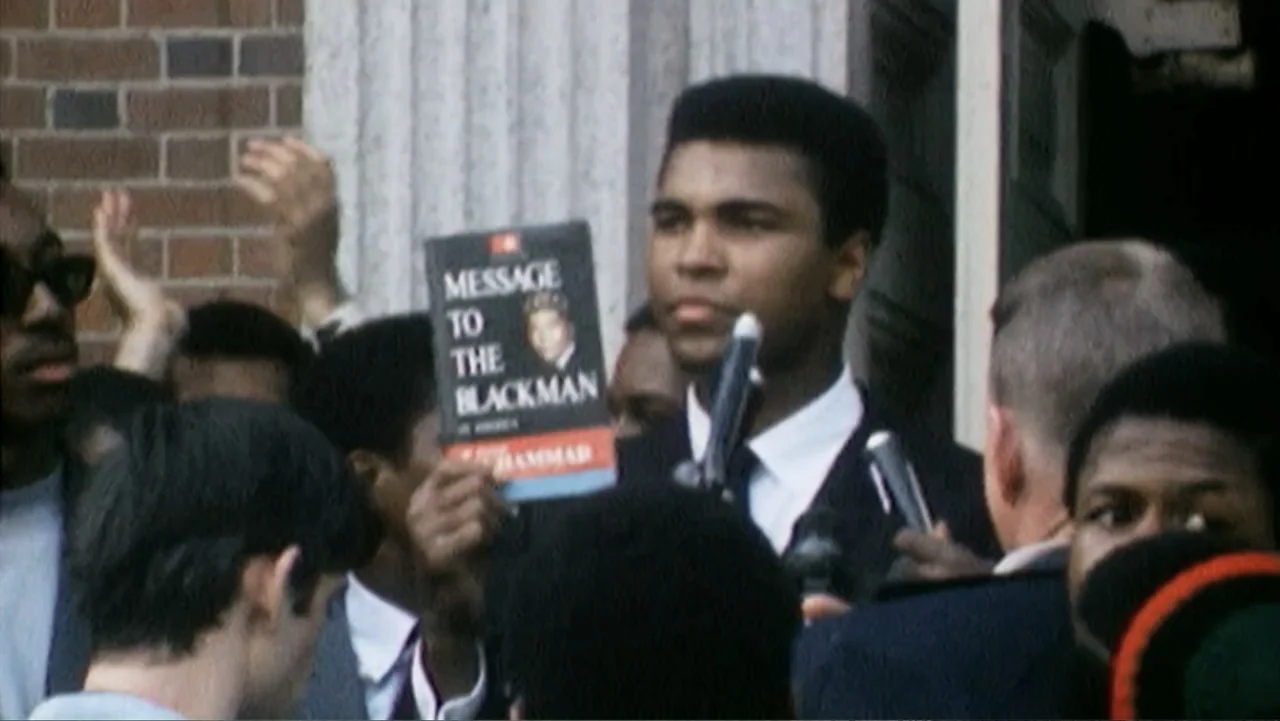 Ali & Cavett: The Tale of the Tapes (2018) movie still: medium — A group of people gathers outdoors in front of a brick building. Muhammad Ali…