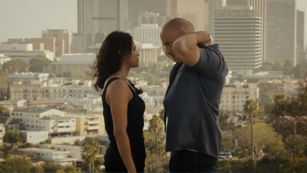 Furious 7 (2015) movie still: medium — A Los Angeles hillside overlooks a distant cityscape during the late afternoon. A man and a woman face each…
