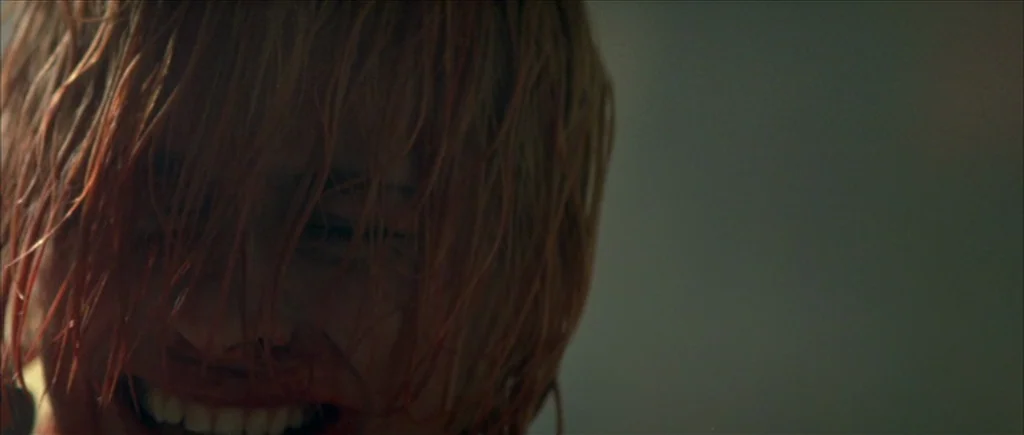 True Romance (1993) movie still: closeup — A close-up view of a person with soaked hair and blood on their face. The subject is looking directly…