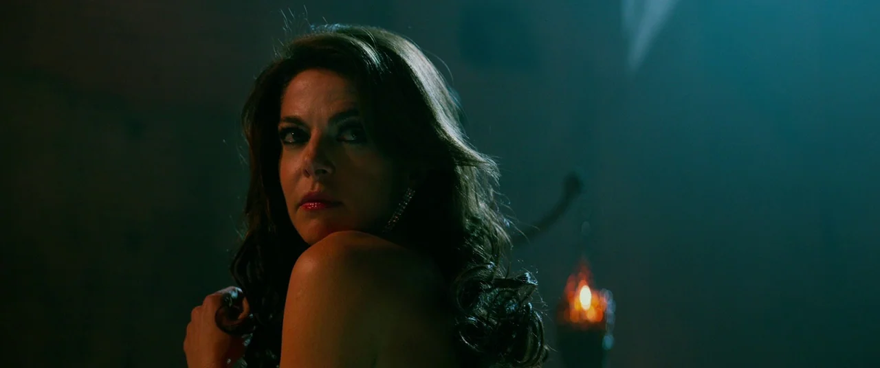 John Wick: Chapter 2 (2017) movie still: closeup — A dimly lit room features a woman positioned against a dark background. She turns her head to…