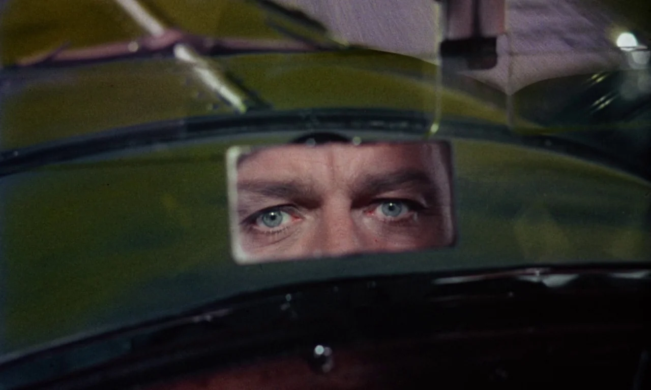 The Devil Rides Out (1968) movie still: closeup — The interior of a vehicle seen from the driver's perspective. A man's eyes are clearly visible in…