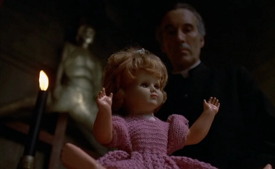 To The Devil a Daughter (1976) movie still: medium — A dark study contains a candle and an anatomical skeletal model in the background. An elderly…