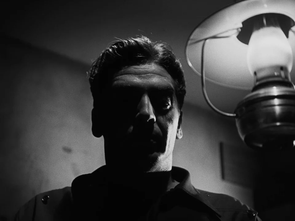 My Darling Clementine (1946) movie still: closeup — A dimly lit space features a man illuminated by a close proximity light source. The man stares…