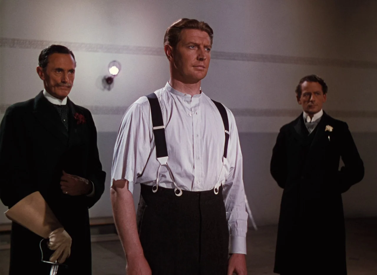 The Life and Death of Colonel Blimp (1943) movie still: medium — Three men stand in a sparse indoor hall with plain walls and overhead fixtures. The…