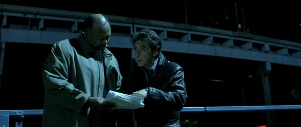 The Insider (1999) movie still: medium — An outdoor overpass area at night features a large concrete bridge structure in background. Two men…