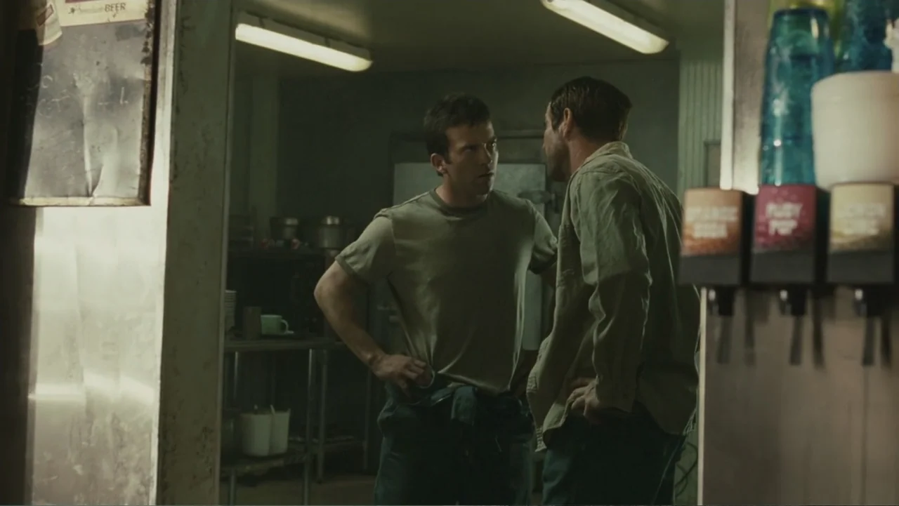 Legion (2010) movie still: medium — A utilitarian commercial kitchen features metallic surfaces and a soda fountain dispenser. Two men in work…
