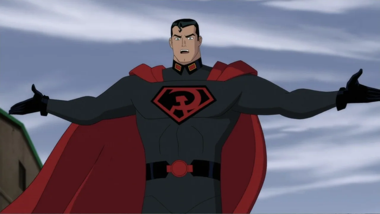 Superman: Red Son (2020) movie still: medium — A man in a black and red costume stands against an overcast sky. He stands with his arms extended…