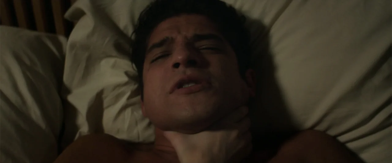 Truth or Dare (2018) movie still: closeup — A close-up view of a person lying on a beige pillow inside a dark bedroom. An unseen hand grips the…