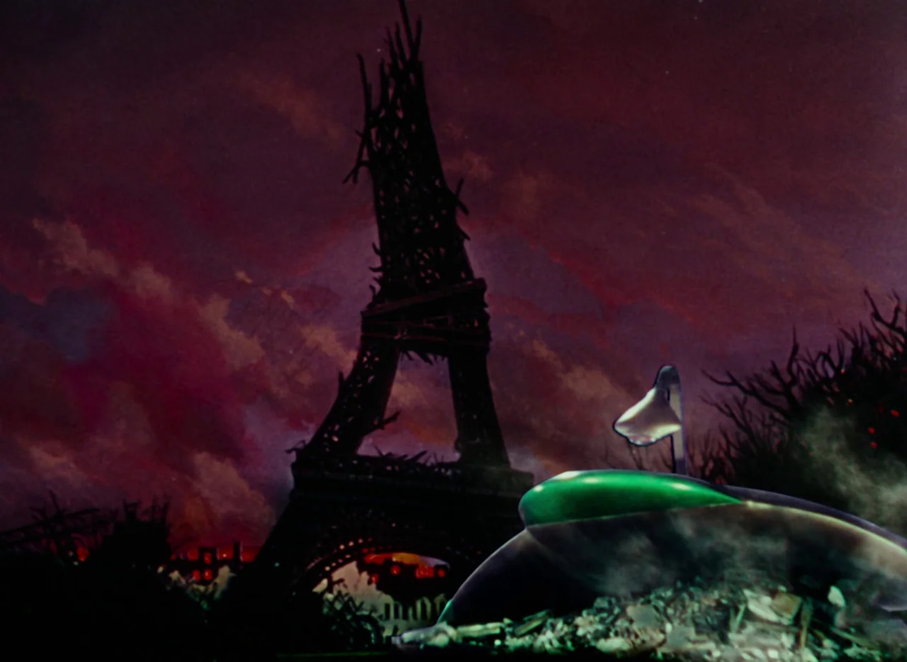 The War of the Worlds (1953) movie still: wide — A dark, ruined cityscape stands under a swirling purple and dark red sky. A partially destroyed…