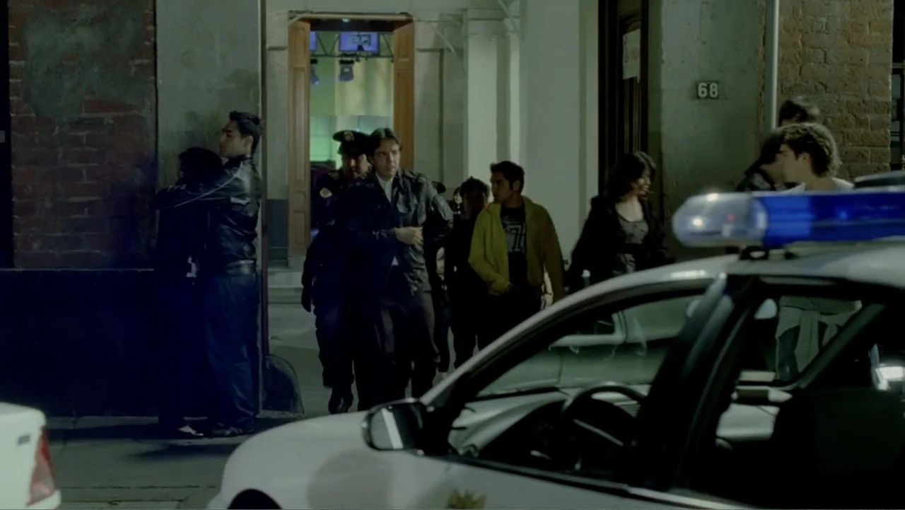 George Lopez: It's Not Me, It's You (2012) movie still: medium — An exterior street scene at night featuring a building entrance with a red brick…