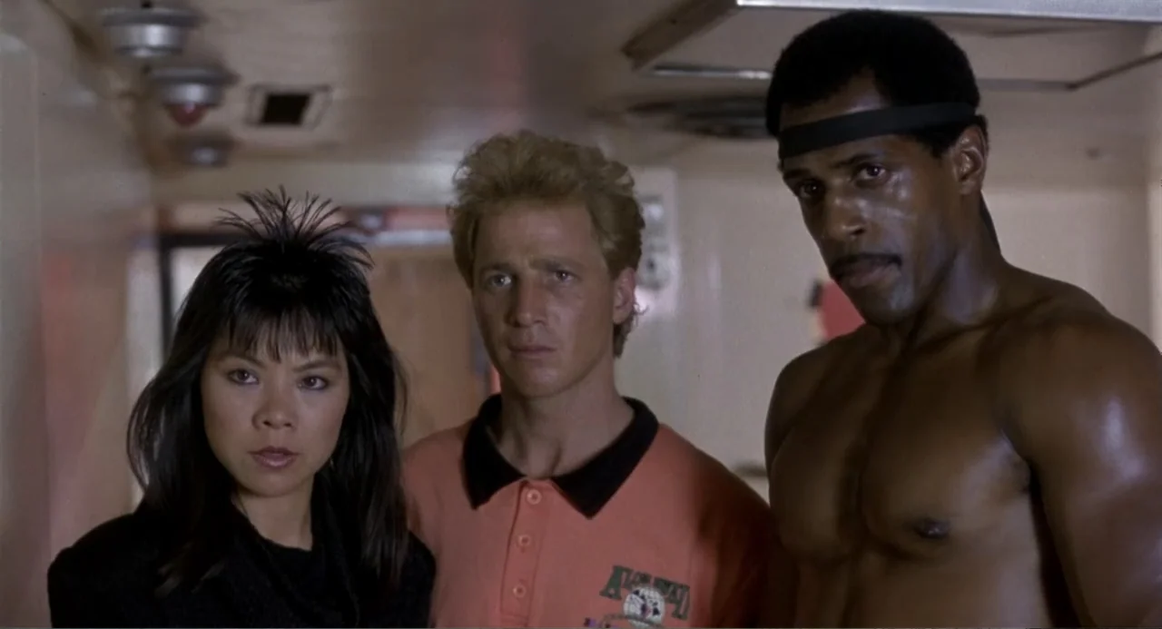 American Ninja 3: Blood Hunt (1989) movie still: medium — An interior corridor features white walls and ceiling fixtures in a commercial space.…