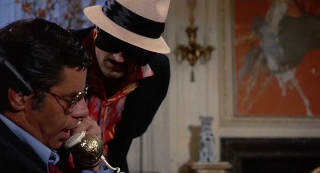 The King Of Comedy (1982) movie still: medium — A dimly lit indoor study features an abstract red painting on the wall. A man talks on an ornate…