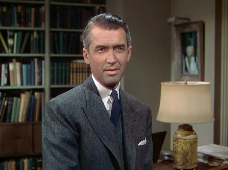 Rope (1948) movie still: medium — A well-appointed interior study features floor-to-ceiling bookshelves filled with organized volumes and a lamp. A…