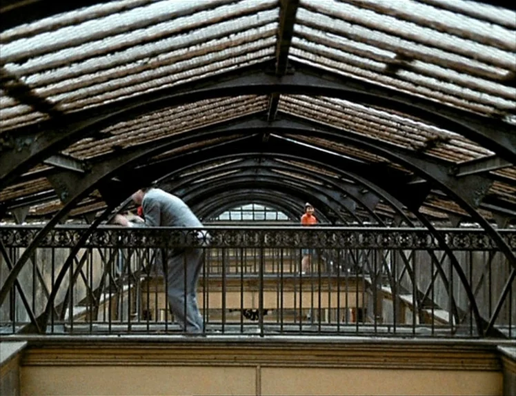 Zazie Dans Le Métro (1960) movie still: wide — A multi-story indoor atrium features an arched ceiling constructed with glass panels and steel…