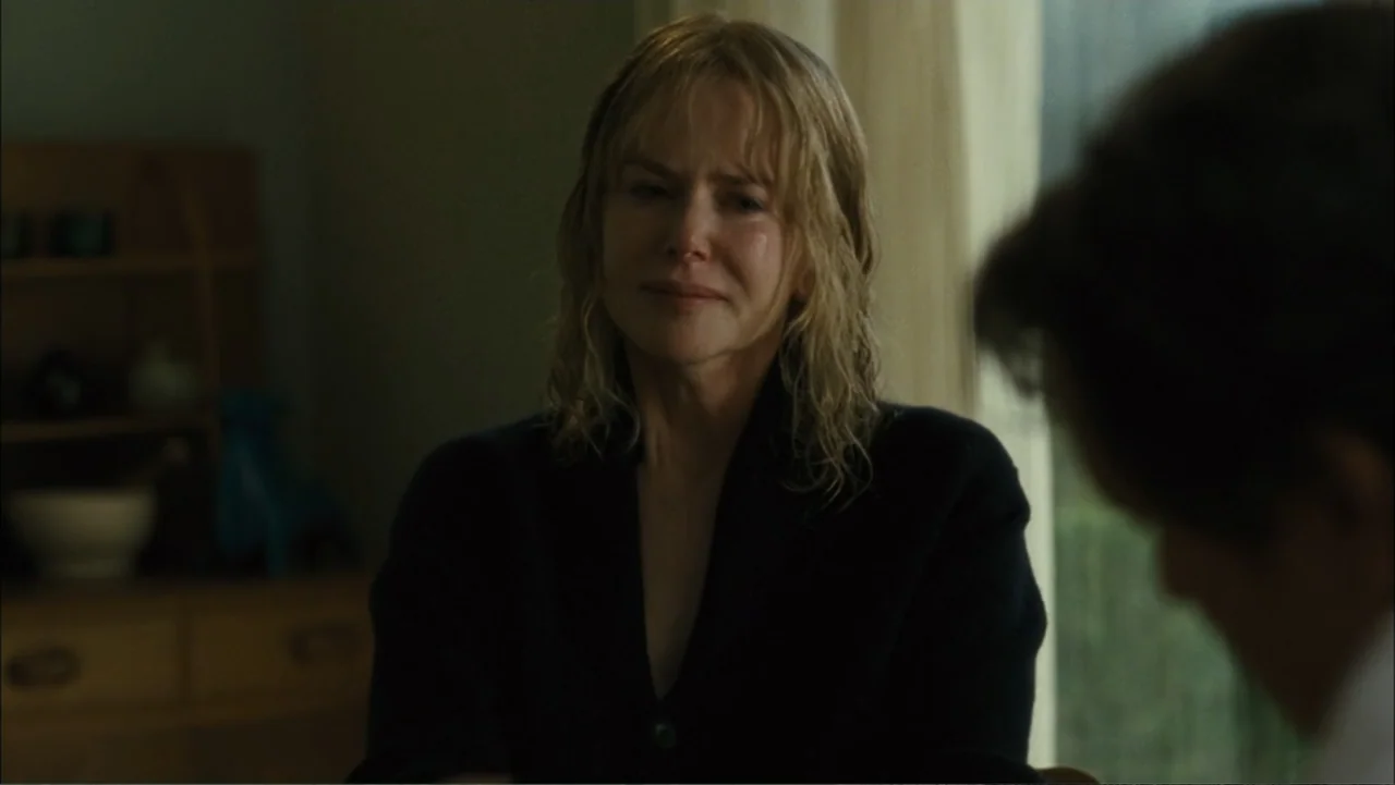 Before I Go to Sleep (2014) movie still: medium — A dimly lit room contains wooden furniture in the background and soft window light. A blonde woman…