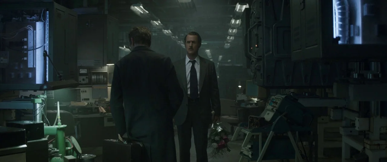 Avengers: Endgame (2019) movie still: medium — An industrial laboratory features dark metal machinery and low-hanging lights in a dim room. Two men…