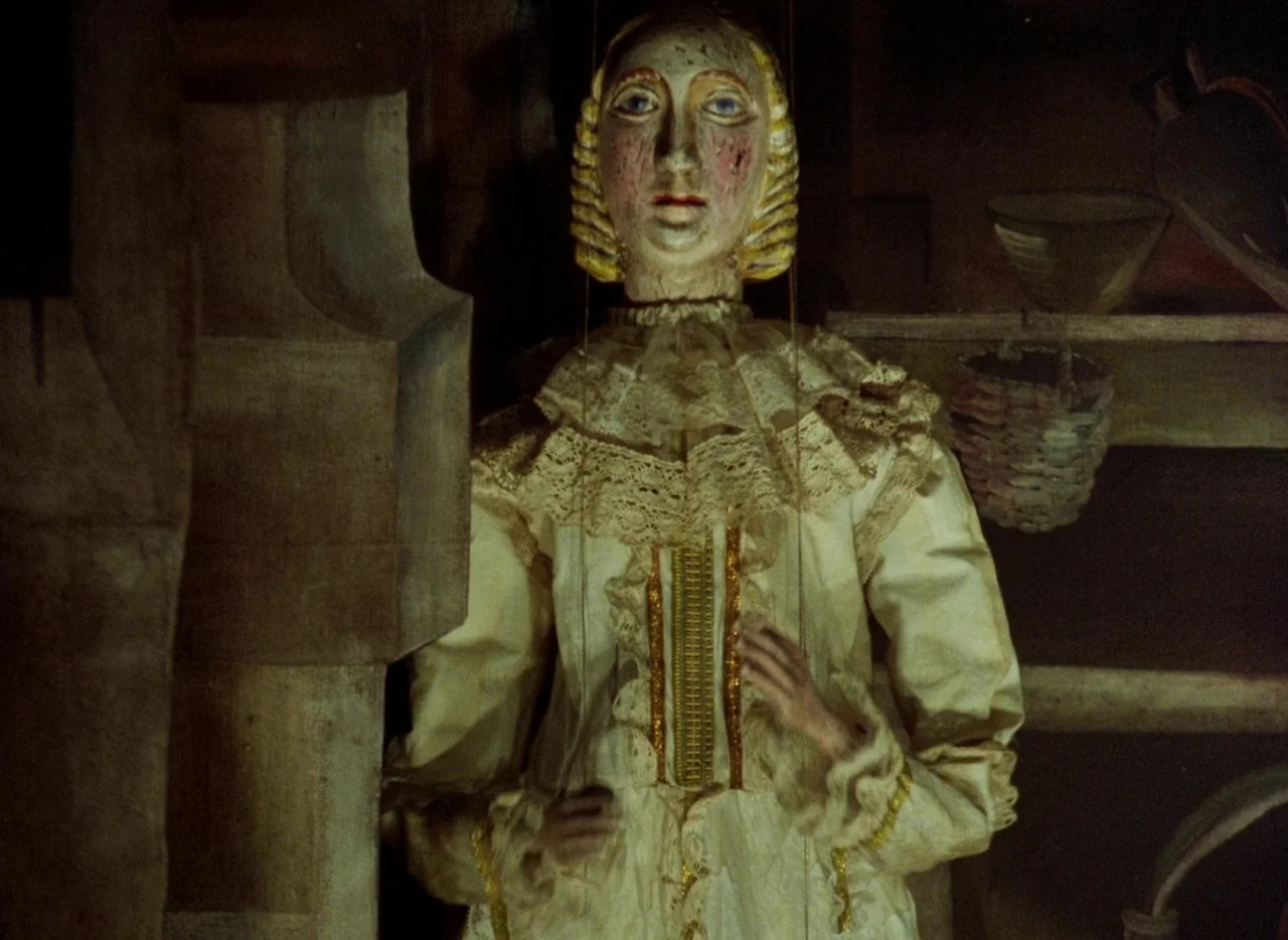 Faust (1994) movie still: medium — A dark, cramped wooden environment contains a vintage wooden marionette against a shadowed wall. The puppet,…