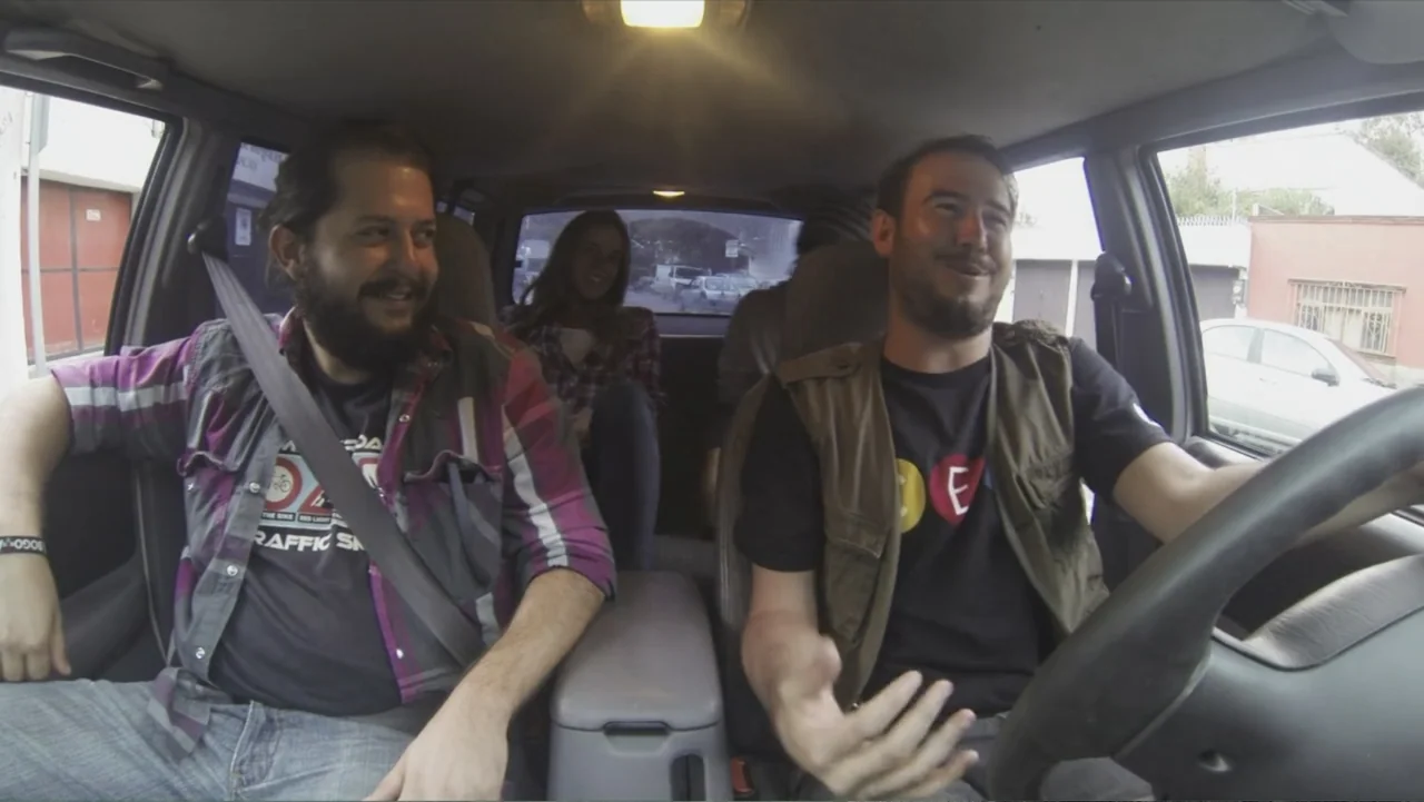 Lost (2010) movie still: medium — The interior of a moving car is shown with two men in the front seats. A woman sits in the back seat visible…