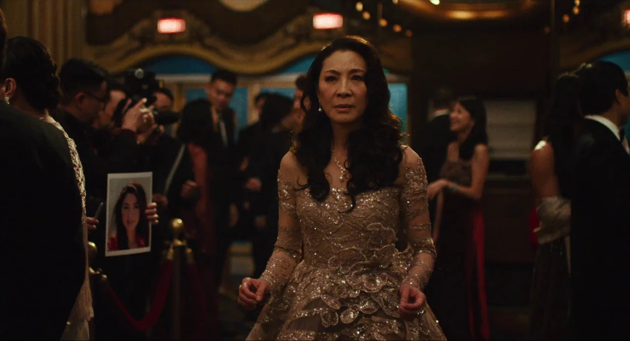 Everything Everywhere All At Once (2022) movie still: medium — A crowded interior hallway features an ornate gold-detailed entryway in the…