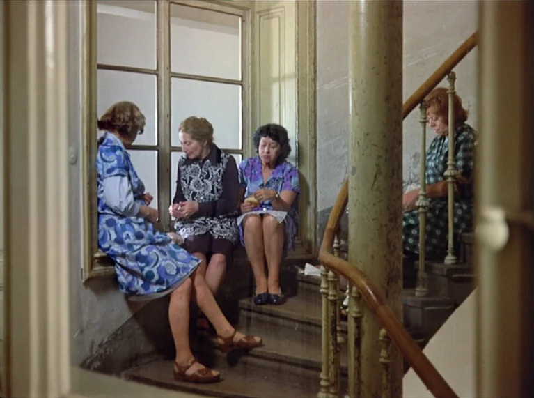 Ali: Fear Eats The Soul (1974) movie still: medium — Four women sit on the wooden steps of a residential building staircase near a window. They are…