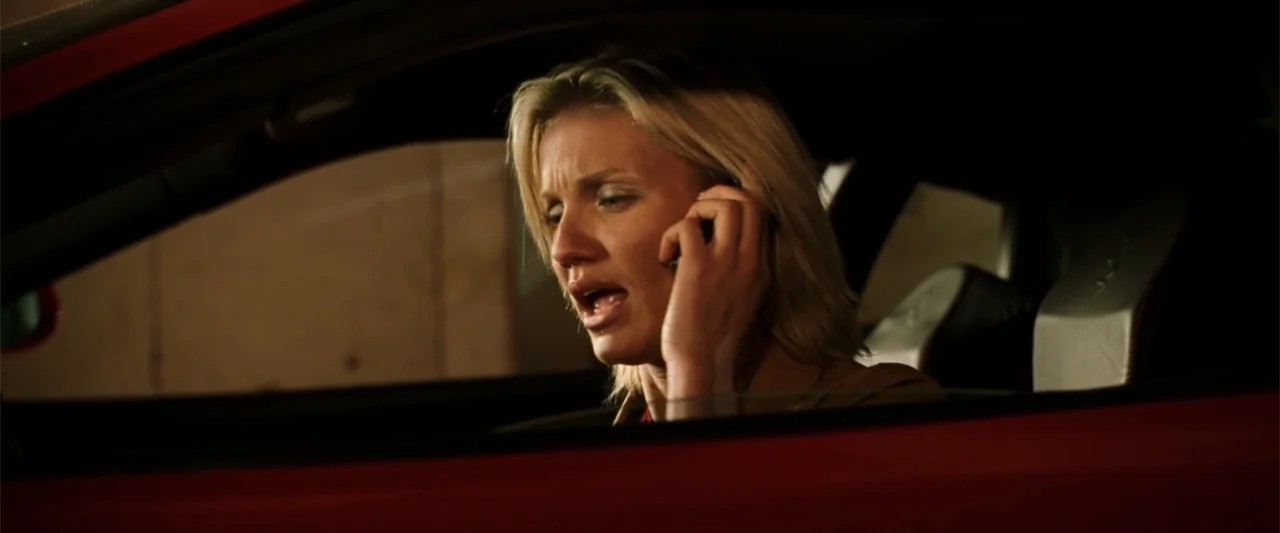 Charlie's Angels (2000) movie still: medium — A dark vehicle interior with red accents on the door and dash. A woman sits in the driver seat…